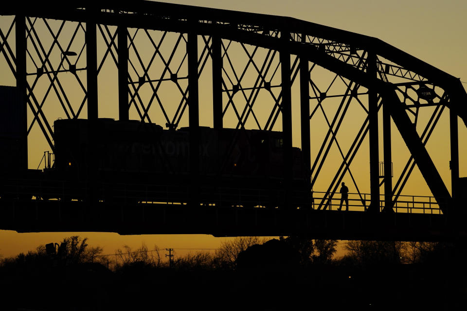 A man walks across the Puente Negro Ferrocarril rail bridge that connects Mexico and the U.S., Wednesday, Jan. 3, 2024, in Eagle Pass, Texas. According to U.S. officials, a Mexican enforcement surge, including forcing migrants off of freight trains and flying and busing migrants to the southern part of country, has contributed to a sharp drop in illegal entries to the U.S. in recent weeks. (AP Photo/Eric Gay)