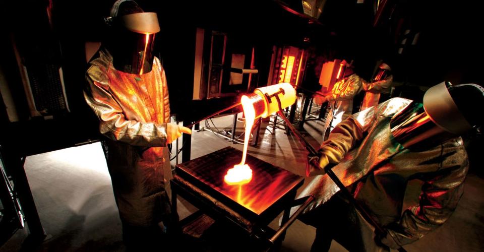 Corning scientists pouring molten glass onto a tray