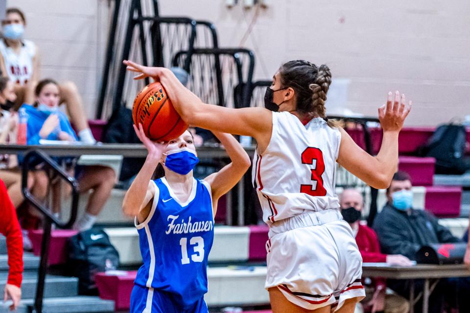 Old Rochester's Logan Fernandes blocks the shot from Tenley Dakin earlier this season. On Wednesday night, Dakin scored the winning basketball to help the Blue Devils capture their first victory of the season.