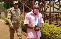 Paul Rusesabagina, portrayed as a hero in a Hollywood movie about Rwanda's 1994 genocide, is escorted in handcuffs from the courtroom in Kigali