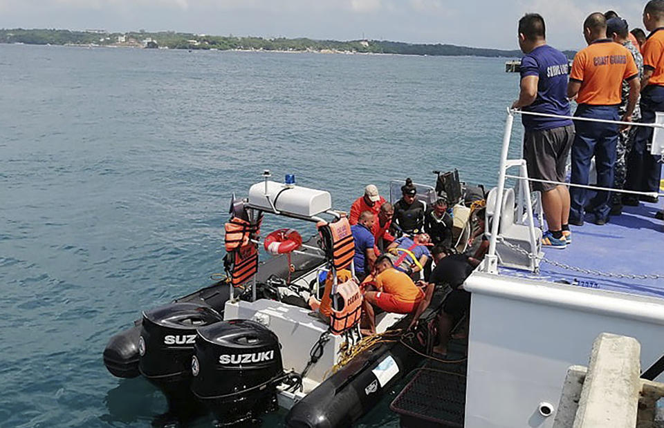 In this photo provided by Philippine Coast Guard in Manila, coast guard personnel carry a survivor to a waiting ambulance after being rescued from a capsized dragon paddle boat off Boracay island resort Wednesday, Sept. 25, 2019, in the central Philippines. The coast guard says seven rowers drowned and 14 others were rescued when their dragon boat was suddenly lashed by strong waves and overturned in the central Philippines. (Philippine Coast Guard Via AP)