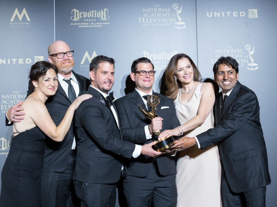 The team behind "Eat the World with Emeril Lagasse" holds their Daytime Emmy.