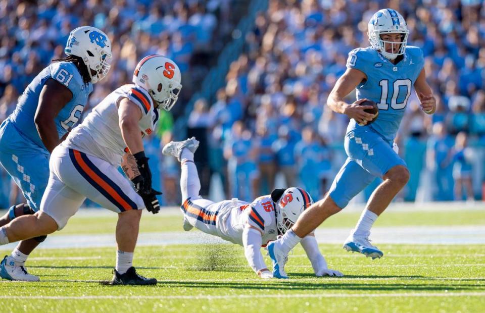 North Carolina quarterback Drake Maye (10) breaks away from Syracuse’s Derek McDonald (15) for a 12-yard gain in the second quarter on Saturday, October 7, 2023 at Kenan Stadium in Chapel Hill, N.C.