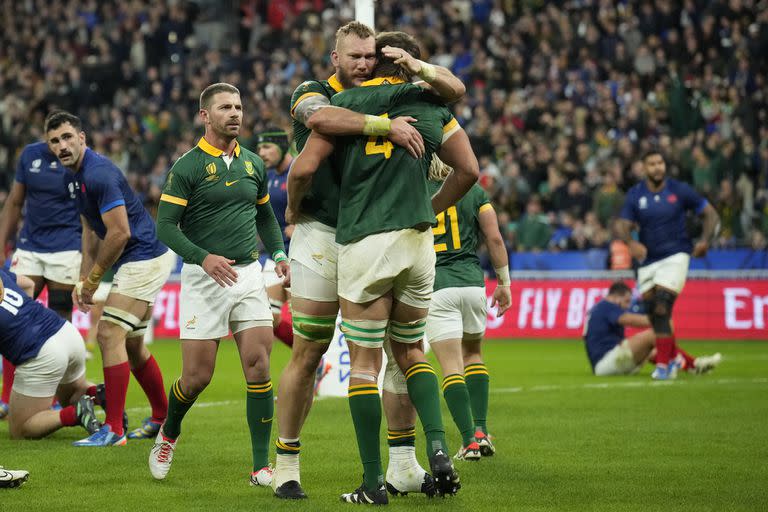 El sudafricano Eben Etzebeth, de espaldas a la cámara, reacciona con sus compañeros de equipo después de marcar un try durante el partido de cuartos de final de la Copa Mundial de Rugby entre Francia y Sudáfrica en el Stade de France en Saint-Denis, cerca de París