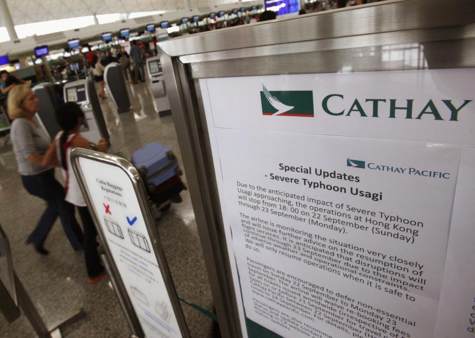 Cathay Pacific Airlines displays a notice on disruptions to its service due to typhoon Usagi, at Hong Kong Airport September 22, 2013. Hong Kong was bracing on Sunday for this year's most powerful typhoon, with government meteorologists warning of severe flooding created by a double whammy of powerful winds and exceptionally high tides. Typhoon Usagi, the strongest storm to hit the Western Pacific this year, is expected to hit the Asian financial center late on Sunday and early on Monday. Cathay Pacific Airways Ltd and its unit Hong Kong Dragon Airlines Ltd will cancel all flights into and out of the international airport from 6 p.m. (1000 GMT) on Sunday. REUTERS/Bobby Yip (CHINA - Tags: ENVIRONMENT TRANSPORT BUSINESS)