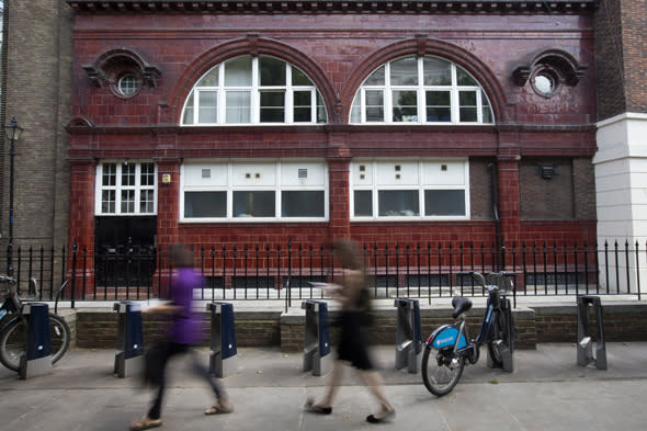 Two tourists walks past Brompton Road underground station, now disused, in central London, Thursday Aug. 8, 2013. The underground station closed in the 1930's and is currently owned by Britain's Ministry of Defence, who used it as an anti-aircraft control point during the second world war. The station is up for sale at 20 million pounds (US$31 million). Though the 28,000 square feet (2,600 square meter) space is just down the road from the famous department store Harrods, it does not enjoy great views of the city. (AP Photo/Alastair Grant)