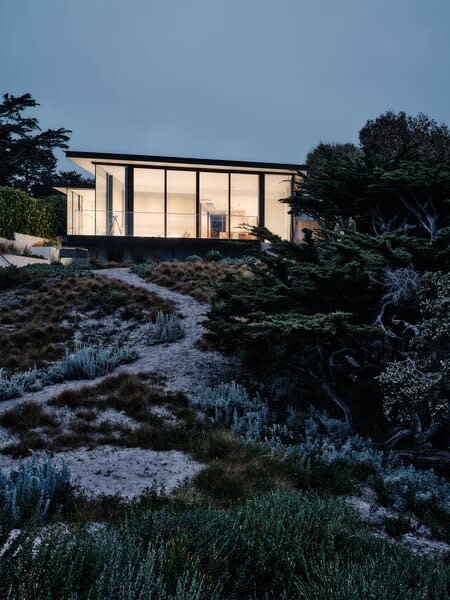 The architects envisioned entry-facing and beach-front sides like an analog camera's viewfinder and wide-angle lens, with the rammed-earth-clad central interior wall leading the way.