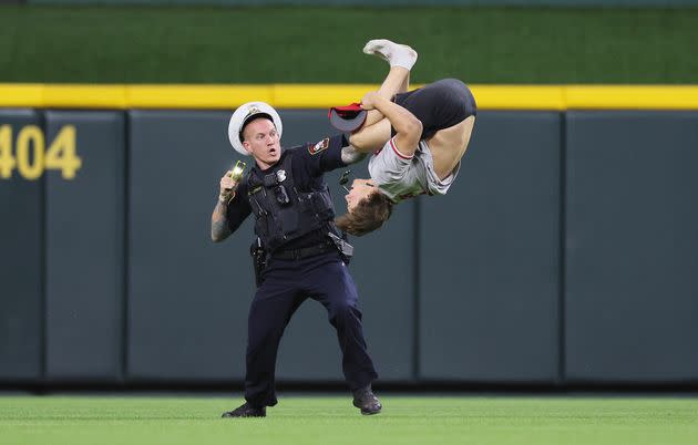 A fan does a flip after he runs on the field before the ninth inning of the Cincinnati Reds against the Cleveland Guardians at Great American Ball Park on Tuesday in Cincinnati, Ohio.