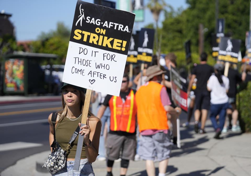 French actor Constance de Calbiac carries a sign on a picket line outside Paramount studios on Wednesday, July 19, 2023, in Los Angeles. The actors strike comes more than two months after screenwriters began striking in their bid to get better pay and working conditions. (AP Photo/Chris Pizzello)