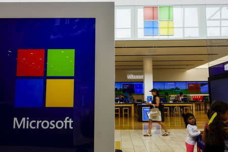 A woman passes by a Microsoft store in Paramus, New Jersey July 8, 2015. REUTERS/Eduardo Munoz