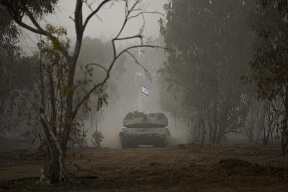 Israeli army tanks move along the Gaza Strip border, in southern Israel, Monday, Dec. 11, 2023. The army is battling Palestinian militants across Gaza in the war ignited by Hamas' Oct. 7 attack into Israel. (AP Photo/Ohad Zwigenberg)