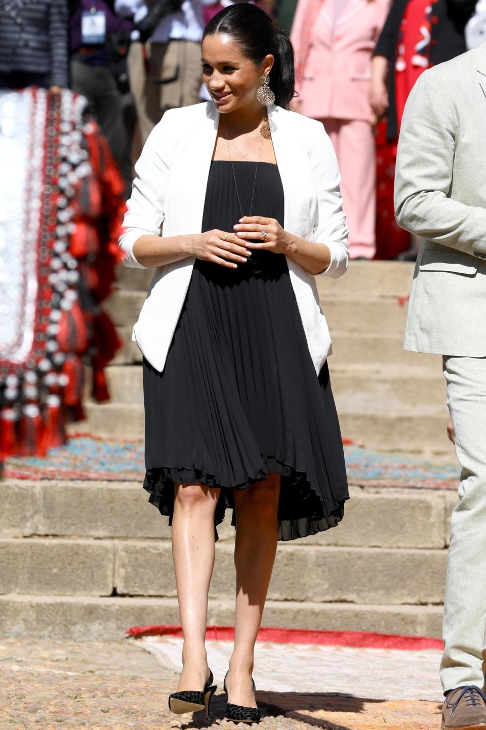 The Duchess of Sussex looked chic as ever on a <a href="https://people.com/royals/meghan-markle-prince-harry-change-outfits-final-day-morocco-tour/" rel="nofollow noopener" target="_blank" data-ylk="slk:trip to the Andalusian Gardens;elm:context_link;itc:0;sec:content-canvas" class="link ">trip to the Andalusian Gardens</a> wearing a white blazer (<a href="https://people.com/royals/meghan-markle-blazers-shop-similar-styles/" rel="nofollow noopener" target="_blank" data-ylk="slk:one of her favorite transitional jacket styles!;elm:context_link;itc:0;sec:content-canvas" class="link ">one of her favorite transitional jacket styles!</a>), plus <a href="https://click.linksynergy.com/deeplink?id=93xLBvPhAeE&mid=42352&murl=https%3A%2F%2Fwww.shopbop.com%2Fpleated-mini-dress-loyd-ford%2Fvp%2Fv%3D1%2F1501821822.htm&u1=PEO%2CShopping%3AEverythingYouNeedtoCopyMeghanMarkle%27sChicSummerStyle%2Ckamiphillips2%2CUnc%2CGal%2C6939680%2C201909%2CI" rel="nofollow noopener" target="_blank" data-ylk="slk:a black pleated dress by Loyd/Ford;elm:context_link;itc:0;sec:content-canvas" class="link ">a black pleated dress by Loyd/Ford</a>, Manolo Blahnik pumps, and gold statement earrings. <strong>Get the Look!</strong> Veronica Beard Scuba Jacket, $600; <a href="https://click.linksynergy.com/deeplink?id=93xLBvPhAeE&mid=1237&murl=https%3A%2F%2Fshop.nordstrom.com%2Fs%2Fveronica-beard-scuba-jacket%2F4377276&u1=PEO%2CShopping%3AEverythingYouNeedtoCopyMeghanMarkle%27sChicSummerStyle%2Ckamiphillips2%2CUnc%2CGal%2C6939680%2C201909%2CI" rel="nofollow noopener" target="_blank" data-ylk="slk:nordstrom.com;elm:context_link;itc:0;sec:content-canvas" class="link ">nordstrom.com</a> ASOS Edition Tailored Blazer with Shawl Collar, $135; <a href="https://click.linksynergy.com/deeplink?id=93xLBvPhAeE&mid=35719&murl=https%3A%2F%2Fus.asos.com%2Fasos-edition%2Fasos-edition-tailored-blazer-with-shawl-collar%2Fprd%2F10934783&u1=PEO%2CShopping%3AEverythingYouNeedtoCopyMeghanMarkle%27sChicSummerStyle%2Ckamiphillips2%2CUnc%2CGal%2C6939680%2C201909%2CI" rel="nofollow noopener" target="_blank" data-ylk="slk:asos.com;elm:context_link;itc:0;sec:content-canvas" class="link ">asos.com</a> I.N.C. International Concepts 3/4-Sleeve Blazer, $79.50; <a href="https://click.linksynergy.com/deeplink?id=93xLBvPhAeE&mid=3184&murl=https%3A%2F%2Fwww.macys.com%2Fshop%2Fproduct%2Fi.n.c.-3-4-sleeve-blazer-created-for-macys%3FID%3D6620939&u1=PEO%2CShopping%3AEverythingYouNeedtoCopyMeghanMarkle%27sChicSummerStyle%2Ckamiphillips2%2CUnc%2CGal%2C6939680%2C201909%2CI" rel="nofollow noopener" target="_blank" data-ylk="slk:macys.com;elm:context_link;itc:0;sec:content-canvas" class="link ">macys.com</a> GUESS Erynn Pleated Dress, $108; <a href="https://click.linksynergy.com/deeplink?id=93xLBvPhAeE&mid=3184&murl=https%3A%2F%2Fwww.macys.com%2Fshop%2Fproduct%2Fguess-erynn-pleated-dress%3FID%3D8100331&u1=PEO%2CShopping%3AEverythingYouNeedtoCopyMeghanMarkle%27sChicSummerStyle%2Ckamiphillips2%2CUnc%2CGal%2C6939680%2C201909%2CI" rel="nofollow noopener" target="_blank" data-ylk="slk:macys.com;elm:context_link;itc:0;sec:content-canvas" class="link ">macys.com</a> ASOS DESIGN Pleated Mini Trapeze Dress, $45; <a href="https://click.linksynergy.com/deeplink?id=93xLBvPhAeE&mid=35719&murl=https%3A%2F%2Fus.asos.com%2Fasos-design%2Fasos-design-pleated-mini-trapeze-dress-with-lace-up-back-detail%2Fprd%2F11165434&u1=PEO%2CShopping%3AEverythingYouNeedtoCopyMeghanMarkle%27sChicSummerStyle%2Ckamiphillips2%2CUnc%2CGal%2C6939680%2C201909%2CI" rel="nofollow noopener" target="_blank" data-ylk="slk:asos.com;elm:context_link;itc:0;sec:content-canvas" class="link ">asos.com</a> Vince Smocked Dress, $445; <a href="https://click.linksynergy.com/deeplink?id=93xLBvPhAeE&mid=42352&murl=https%3A%2F%2Fwww.shopbop.com%2Fsmocked-dress-vince%2Fvp%2Fv%3D1%2F1599788007.htm&u1=PEO%2CShopping%3AEverythingYouNeedtoCopyMeghanMarkle%27sChicSummerStyle%2Ckamiphillips2%2CUnc%2CGal%2C6939680%2C201909%2CI" rel="nofollow noopener" target="_blank" data-ylk="slk:shopbop.com;elm:context_link;itc:0;sec:content-canvas" class="link ">shopbop.com</a> Kate Spade New York Scallop Pleated Dress, $398; <a href="https://click.linksynergy.com/deeplink?id=93xLBvPhAeE&mid=1237&murl=https%3A%2F%2Fshop.nordstrom.com%2Fs%2Fkate-spade-new-york-scallop-pleat-sweater-dress%2F5204685&u1=PEO%2CShopping%3AEverythingYouNeedtoCopyMeghanMarkle%27sChicSummerStyle%2Ckamiphillips2%2CUnc%2CGal%2C6939680%2C201909%2CI" rel="nofollow noopener" target="_blank" data-ylk="slk:nordstrom.com;elm:context_link;itc:0;sec:content-canvas" class="link ">nordstrom.com</a> ASOS DESIGN Backless Halter Pleated Midi Dress, $56; <a href="https://click.linksynergy.com/deeplink?id=93xLBvPhAeE&mid=35719&murl=https%3A%2F%2Fus.asos.com%2Fasos-design%2Fasos-design-backless-halter-pleated-midi-dress%2Fprd%2F11170642&u1=PEO%2CShopping%3AEverythingYouNeedtoCopyMeghanMarkle%27sChicSummerStyle%2Ckamiphillips2%2CUnc%2CGal%2C6939680%2C201909%2CI" rel="nofollow noopener" target="_blank" data-ylk="slk:asos.com;elm:context_link;itc:0;sec:content-canvas" class="link ">asos.com</a>