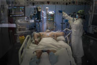 A COVID-19 patient receives treatment in the ICU of the Hospital del Mar, in Barcelona, Spain, Tuesday, Jan. 19, 2021. The unrelenting increase in COVID-19 infections in Spain following the holiday season is again straining hospitals, threatening the mental health of doctors and nurses who have been at the forefront of the pandemic for nearly a year. (AP Photo/Felipe Dana)