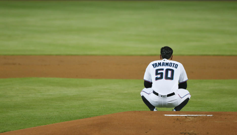 Miami Marlins starting pitcher Jordan Yamamoto takes a moment behind the mound before pitching during the first inning of the team's baseball game against the St. Louis Cardinals, Wednesday, June 12, 2019, in Miami. Yamamoto pitched seven innings, winning his major league debut, in the Marlins' 9-0 victory. (AP Photo/Wilfredo Lee)