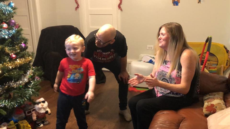 Davis Cameron, left, dancing beside his parents Terry Graham, centre and Courtney Cameron, right. Four-year-old Davis is on the autism spectrum and his mother is fighting to keep his son in school all day. (TJ Dhir/CBC - image credit)