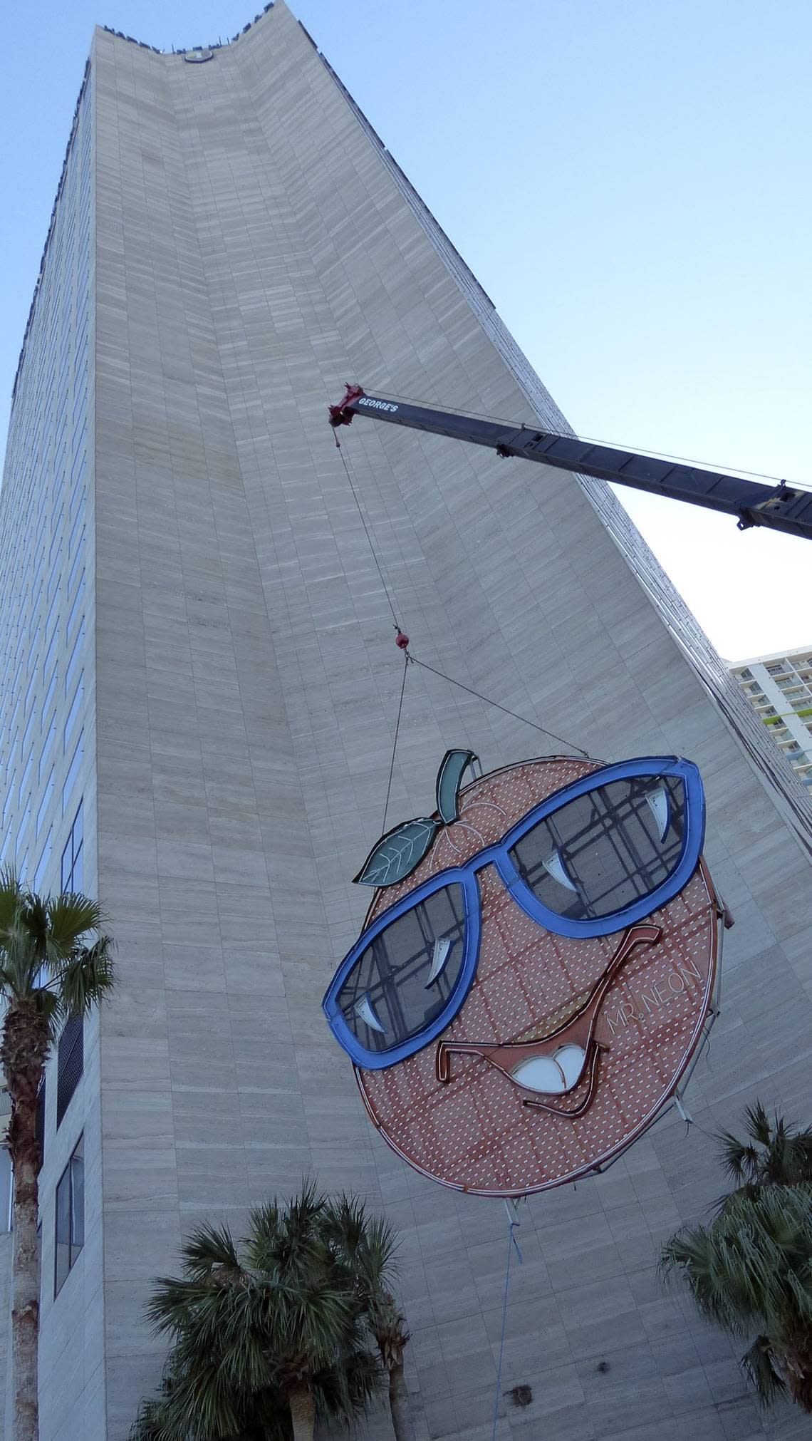 The Big Orange neon sign is lifted to the side of the InterContinental Hotel on Dec. 27, 2012 in preparation for the New Year’s ride to the top of the building.