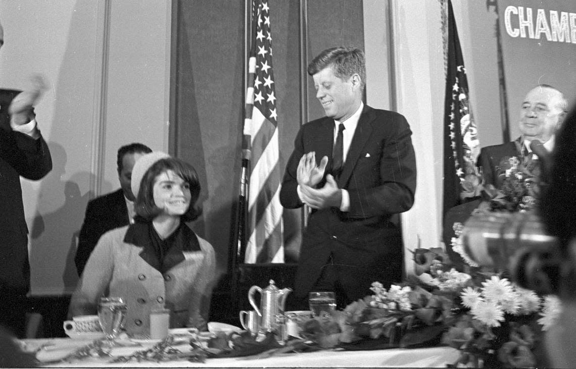 President John F. Kennedy applauds his wife Jacqueline during introductions at the Fort Worth Chamber of Commerce breakfast, Hotel Texas, 11/22/1963