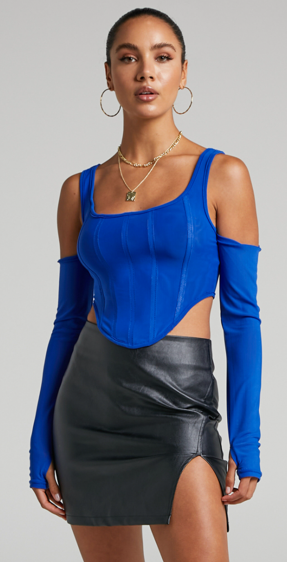 A model wears a cropped blue bustier top, long gloves and a black mini skirt.