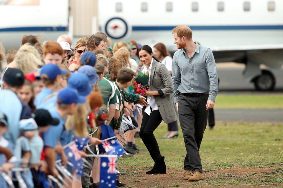 Prince Harry and Meghan Markle greeting school kids