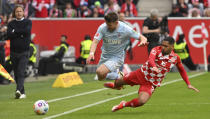 Mainz's Phillip Mwene, right, and Cologne's Jan Thielmann battle for the ball during the Bundesliga soccer match between FSV Mainz 05 and 1. FC Koln at Mewa Arena, Mainz, Germany, Sunday April 28, 2024. (Torsten Silz/dpa via AP)