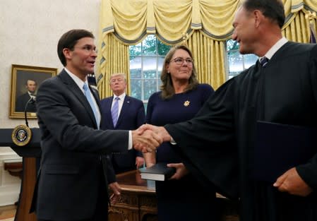 U.S. President Donald Trump looks on as Mark Esper shakes hands with Associate Justice Samuel Alito after Esper was sworn in as the new Secretary of Defense while Esper's wife Leah Esper stands nearby in the Oval Office of the White House