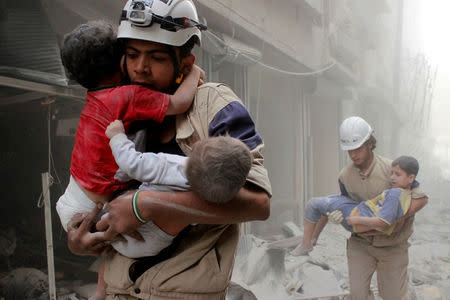 Members of the Civil Defence rescue children after what activists said was an air strike by forces loyal to Syria's President Bashar al-Assad in al-Shaar neighbourhood of Aleppo, Syria June 2, 2014. REUTERS/Sultan Kitaz