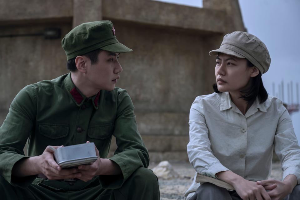 yang weining and ye wenjie sit outside in three problem bodies, wearing utilitarian clothes