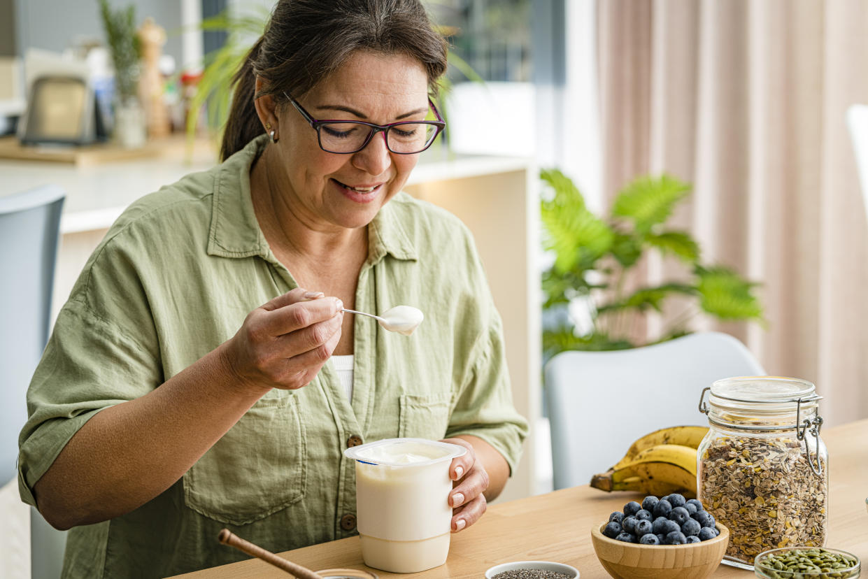 Woman eating greek yogurt. High resolution 42Mp studio digital capture taken with Sony A7rII and Sony FE 90mm f2.8 macro G OSS lens