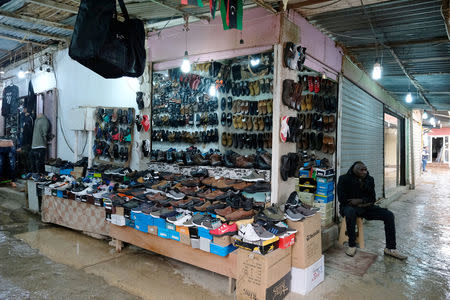 A vendor sits next to his shoe stall as he waits for customers at the popular market in Derna, Libya, February 9, 2019. Picture taken February 9, 2019. REUTERS/Esam Omran Al-Fetori