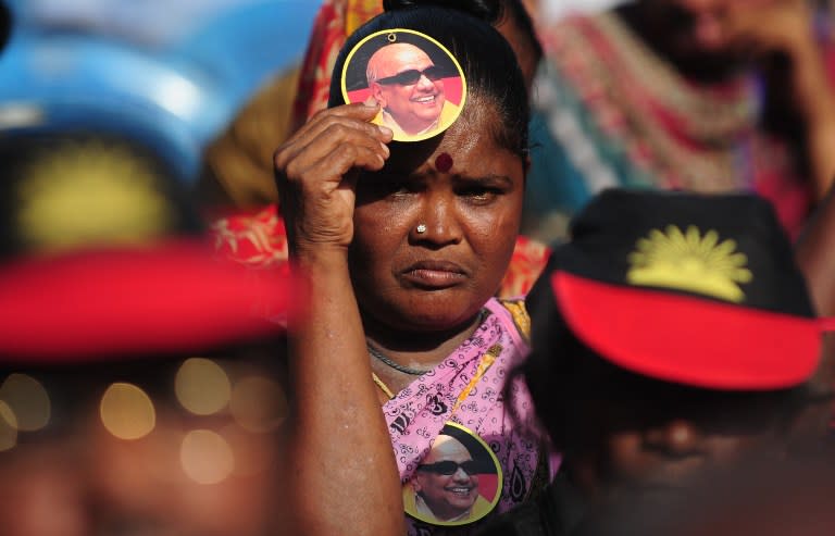 <p>An Indian supporter of the leader of the Dravida Munnetra Kazhagam (DMK) party M. Karunanithi holds a badge bearing his image during an election rally in Chennai on May 14, 2016. State assembly elections are due to take place in the southern Indian state of Tamil Nadu on May 16. </p>