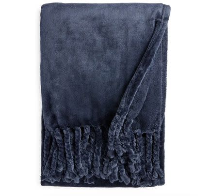 A dreamy plush throw blanket with twisted fringe
