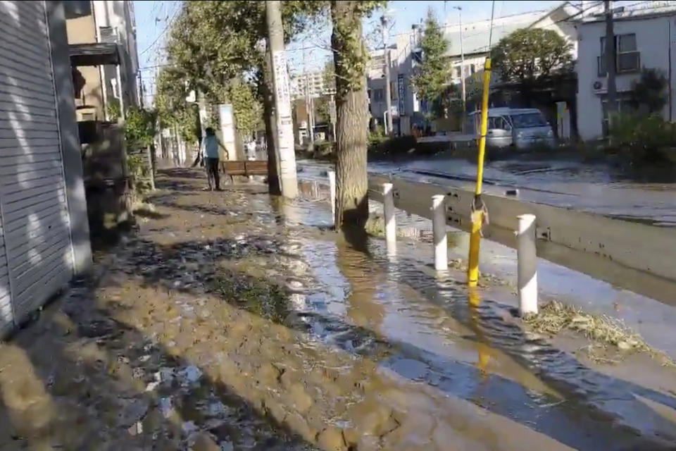 This image made from a video by @ar_kaz shows the mud covered street after the flood water receded on the morning Sunday, Oct. 13, 2019, in Kawasaki, near Tokyo, Japan. Helicopters plucked people from their flooded homes on Sunday as rescue efforts went into full force in wide areas of Japan, including Tokyo, after a powerful typhoon unleashed heavy rainfall.(@ar_kaz via AP)