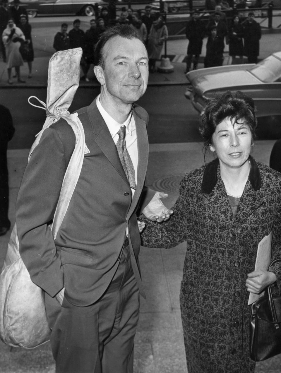 FILE - In this April 4, 1961 file photo, Pete Seeger, with a banjo slung over his shoulder, is accompanied by his wife, Toshi, as he arrives at the federal court in New York for sentencing on a conviction for contempt of Congress. The town of Beacon, N.Y. plans to honor the couple by renaming a riverside park in their honor, which is seen as a fitting tribute since they were instrumental in converting the former dump into Riverfront Park. (AP Photo)