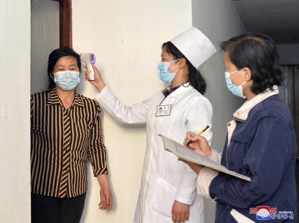 In this photo provided by the North Korean government, a doctor checks a resident's temperature to curb the spread of coronavirus infection, in Pyongyang, North Korea Tuesday, May 17, 2022. Independent journalists were not given access to cover the event depicted in this image distributed by the North Korean government. The content of this image is as provided and cannot be independently verified. Korean language watermark on image as provided by source reads: "KCNA" which is the abbreviation for Korean Central News Agency. (Korean Central News Agency/Korea News Service via AP)