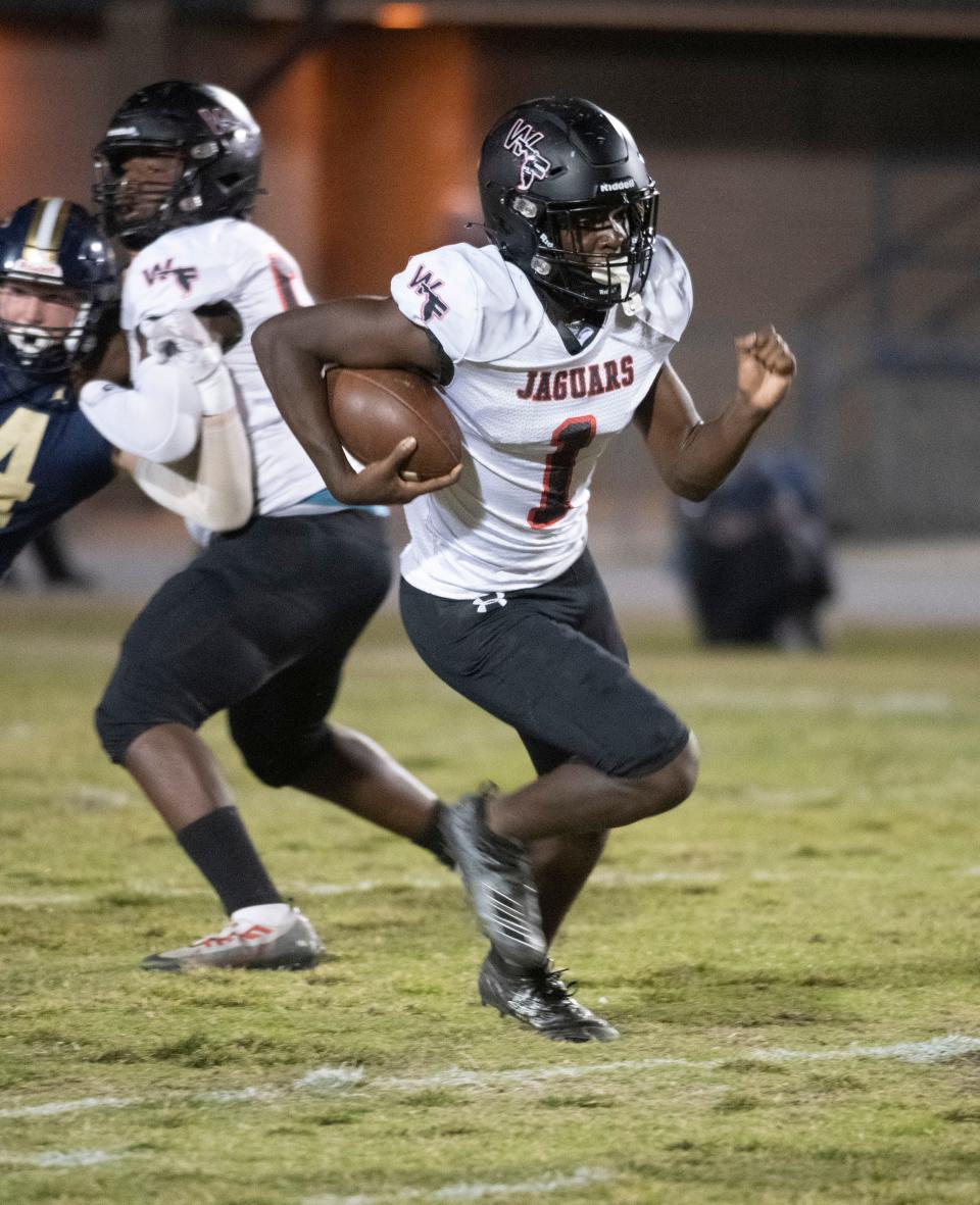 West Florida quarterback Markell Redding (No. 1) breaks through the line of scrimmage for a gain in yards during Friday night's gridiron matchup against Gulf Breeze.