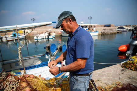 Greek fisherman Thanassis Marmarinos, 63, repairs his fishing nets at the port of the Skala Sikamias village on the island of Lesbos, Greece, October 5, 2016. REUTERS/Alkis Konstantinidis