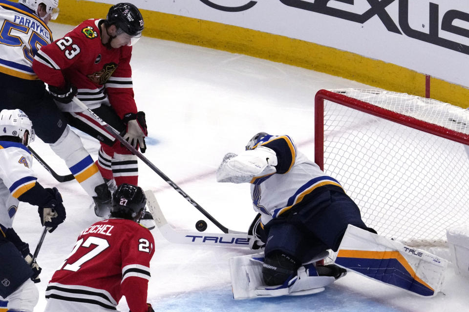 St. Louis Blues goaltender Jordan Binnington, right, saves a shot by Chicago Blackhawks center Philipp Kurashev (23) during the second period of an NHL hockey game in Chicago, Sunday, Nov. 26, 2023. (AP Photo/Nam Y. Huh)