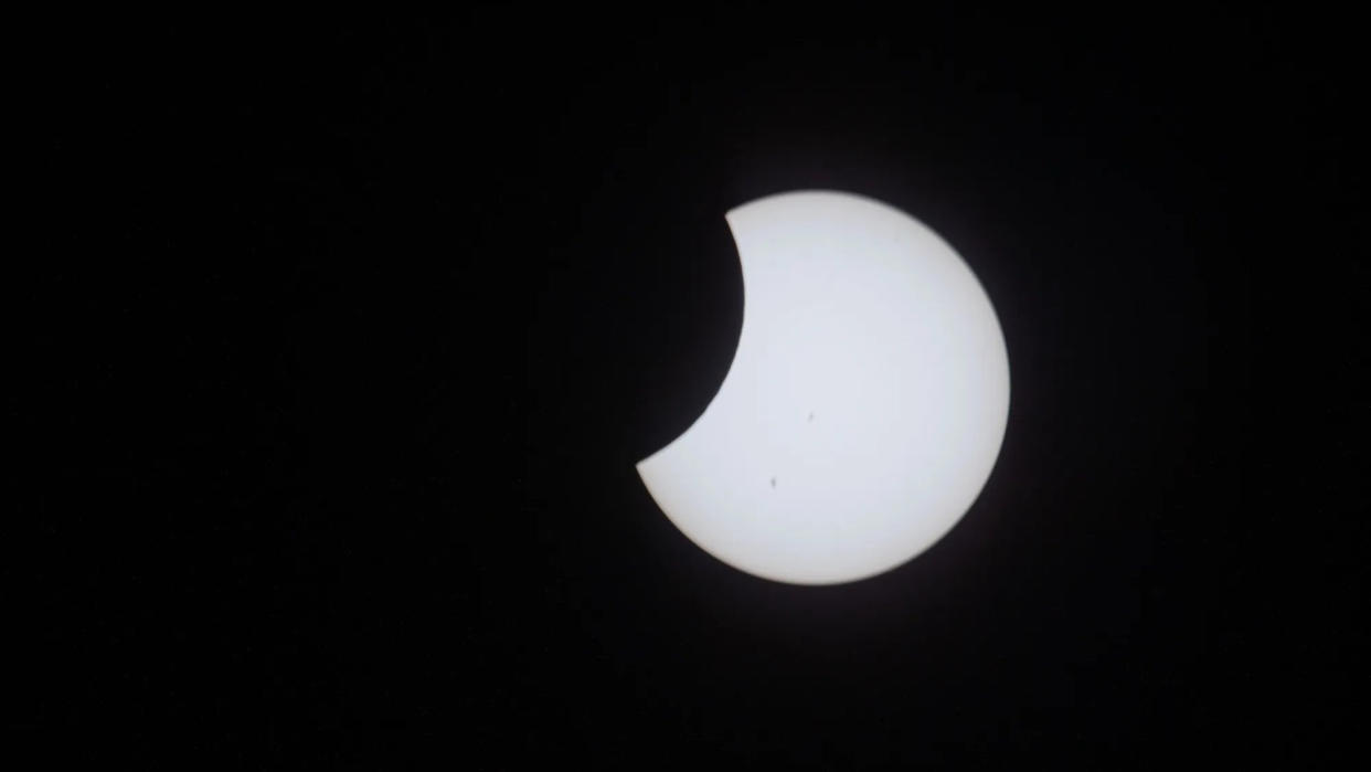  A solar eclipse in progress with the moon starting to cover part of the sun. 