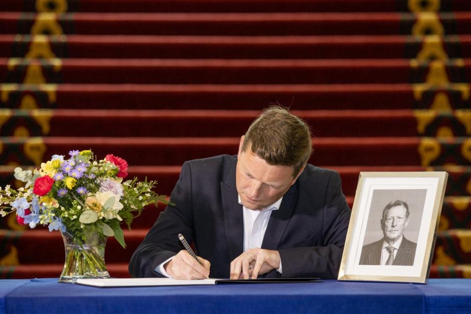 SDLP councillor Donal Lyons signs a book of condolence opened at Belfast City Hall for Lord David Trimble (Liam McBurney/PA) (PA Wire)