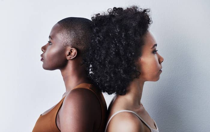 Two women standing back to back