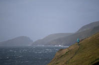 A woman climbs a cliff on Slea Head during Storm Ali in Coumeenoole, Ireland, September 19, 2018. REUTERS/Clodagh Kilcoyne