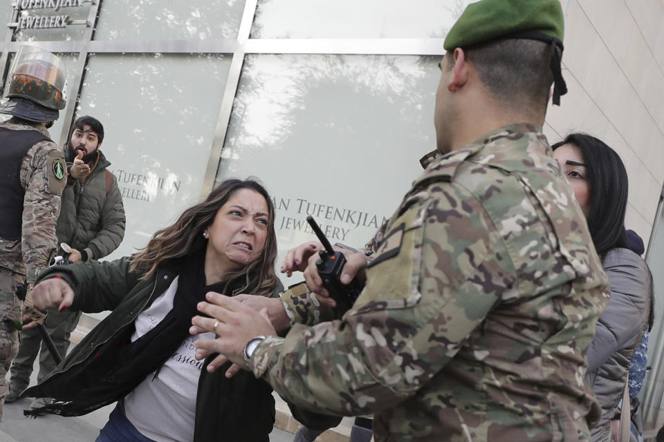 Army soldiers scuffle with anti-government protesters blocking a road leading to the parliament building in downtown Beirut, Lebanon, Monday, Jan. 27, 2020. Lebanese security forces scuffled Monday with protesters near the parliament building in downtown Beirut where lawmakers are scheduled to begin a two-day discussion and later approval of the budget amid a crippling financial crisis. (AP Photo/Hassan Ammar)