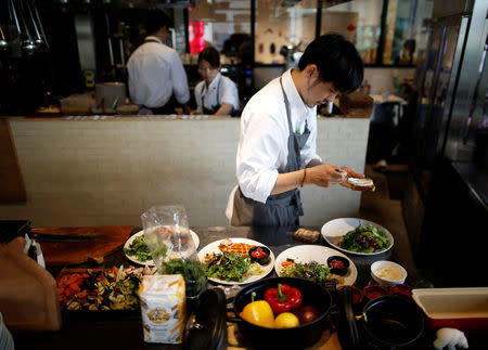 Chefs prepare dishes at HyLife Pork Table, a pork dish restaurant operated by Canadian pig farmer and pork processor HyLife, at Daikanyama district in Tokyo, Japan October 31, 2016. REUTERS/Issei Kato