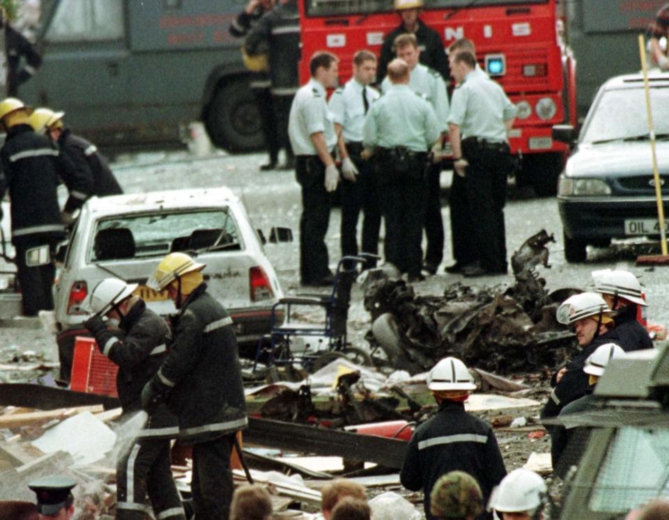 Royal Ulster Constabulary police officers and firefighters inspecting the damage caused by a bomb explosion in Market Street, Omagh, Co Tyrone (PA) (PA Wire)