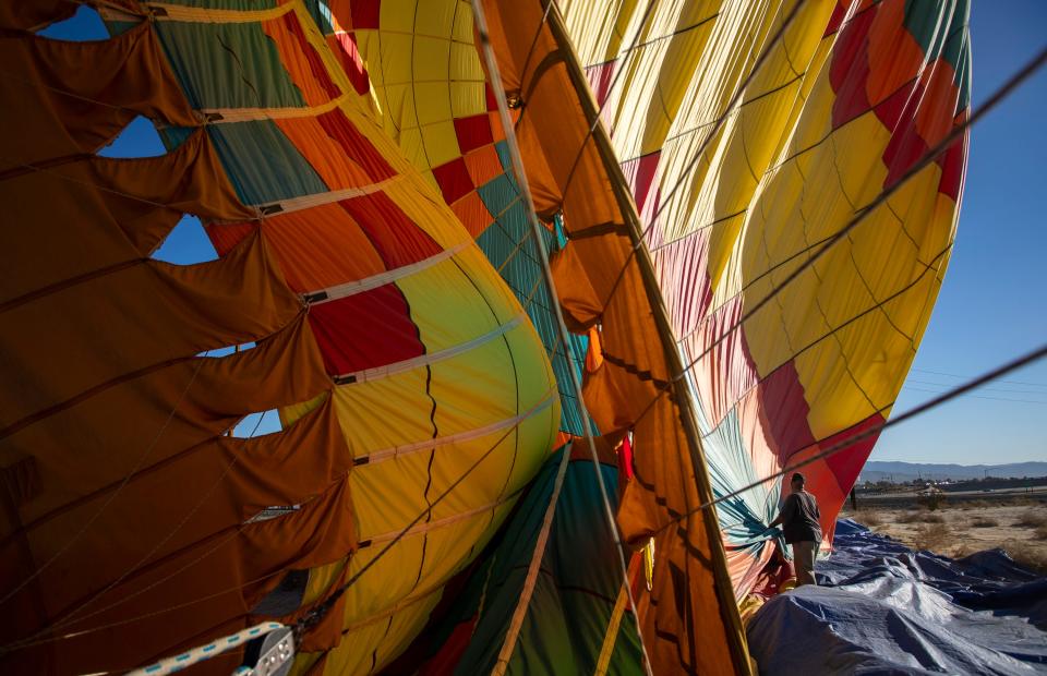 Crew member Vince Garcia helps break down his team's balloon after a landing Friday in Palm Desert during the annual Cathedral City Hot Air Balloon Festival.