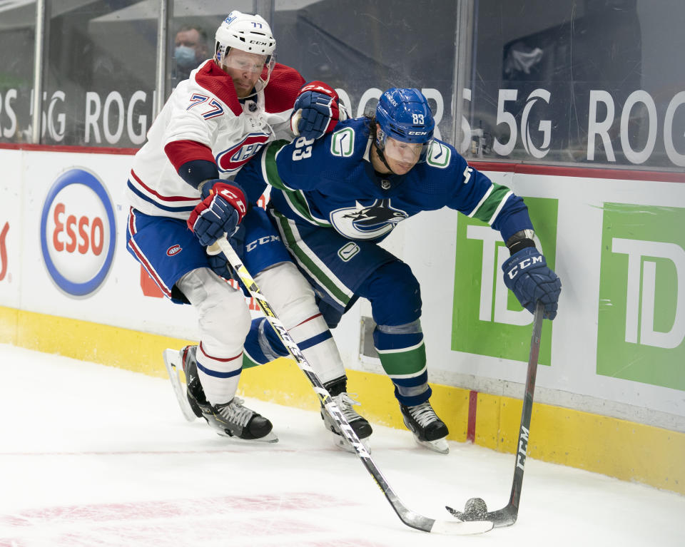 Vancouver Canucks center Jay Beagle (83) fights for control of the puck with Montreal Canadiens defenseman Brett Kulak (77) during the second period of an NHL hockey game Wednesday, Jan. 20, 2021, in Vancouver, British Columbia. (Jonathan Hayward/The Canadian Press via AP)