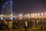 People crowded on the beach in Barcelona, Spain, Sunday, May 9, 2021. Barcelona residents were euphoric as the clock stroke midnight, ending a six-month-long national state of emergency and consequently, the local curfew. Spain is relaxing overall measures to contain the coronavirus this weekend, allowing residents to travel across regions, but some regional chiefs are complaining that a patchwork of approaches will replace the six-month-long national state of emergency that ends at midnight on Saturday. (AP Photo/Emilio Morenatti)