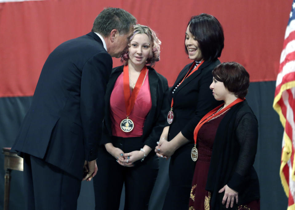Ohio Gov. John Kasich, from left, talks with Amanda Berry, Gina DeJesus and Michelle Knight after they received the Governor's Courage Award, during Kasich's State of the State address at the Performing Arts Center Monday, Feb. 24, 2014, in Medina, Ohio. The three women survived a decades-long captivity in Cleveland before being rescued in May when Berry pushed her way through a door to freedom. (AP Photo/Tony Dejak)