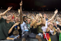Noah Lyles from the USA reacts together with fans after winning the men's 100m race, during the Weltklasse IAAF Diamond League international athletics meeting in the stadium Letzigrund in Zurich, Switzerland, Thursday, August 29, 2019. (Jean-Christophe Bott/Keystone via AP)