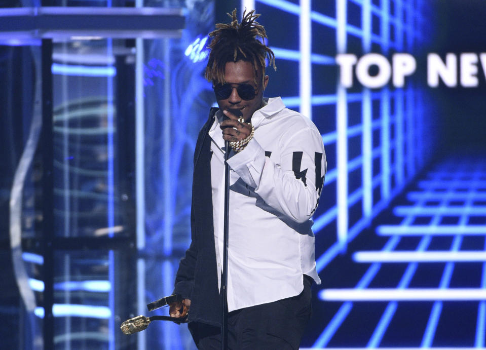 FILE - In this May 1, 2019 file photo, Juice WRLD accepts the award for top new artist at the Billboard Music Awards at the MGM Grand Garden Arena in Las Vegas. The Chicago-area rapper, whose real name is Jarad A. Higgins, was pronounced dead Sunday, Dec. 8 after a "medical emergency'' at Chicago's Midway International Airport, according to authorities. Chicago police said they're conducting a death investigation. (Photo by Chris Pizzello/Invision/AP, File)